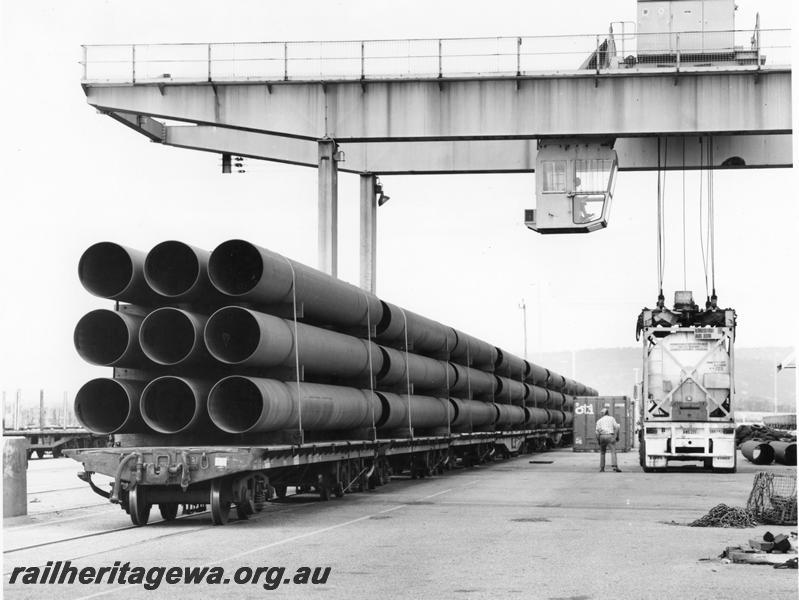 P00406
Bogie flat wagons loaded with pipes for the North West shelf gas pipeline, overhead gantry crane, Kewdale, view along the row of wagons.
