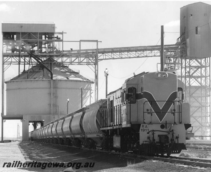 P00532
RA class 1911 in Westrail orange livery, alumina train passing under a loader

