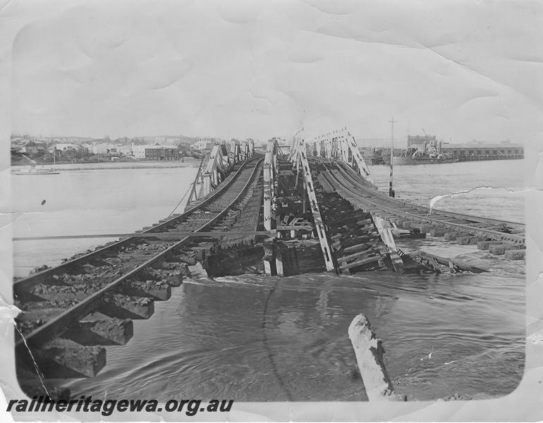 P00592
Fremantle Railway Bridge collapse which occurred on the afternoon of the 22nd of July, 1926, view along the bridge with the rails suspended over the gap due to the washaway, ER line, See also P05184
