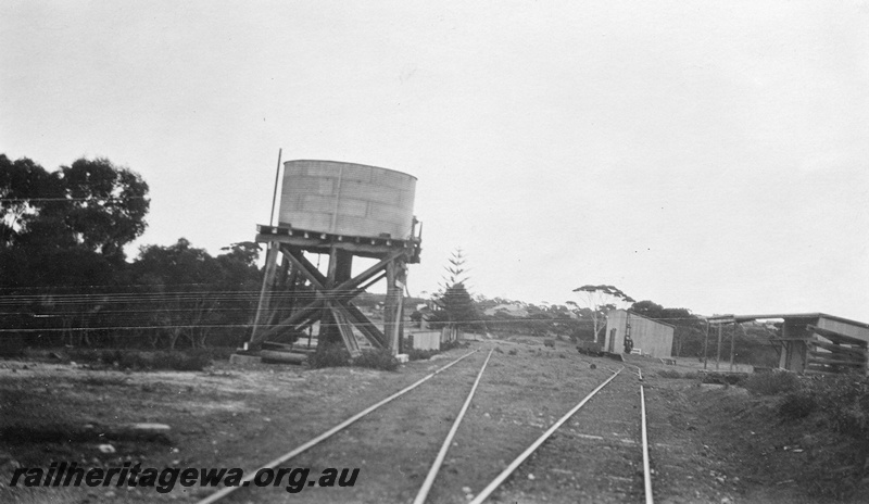P01422
1 of 4 images of the buildings and other structures at the Ravensthorpe station precinct, HR line, water tower with a cylindrical tank, station building, carpenter's shed, goods shed and wheat stacking areas on top of the cutting
