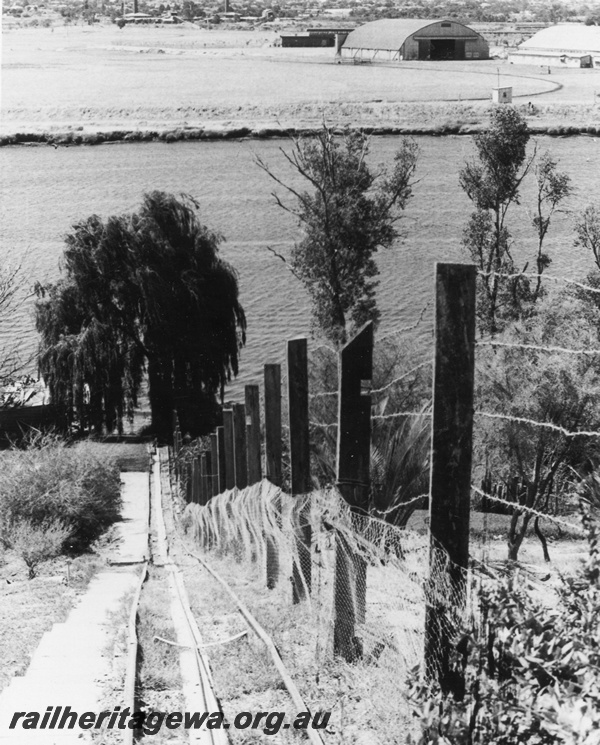 P02278
26' tramway leading down to the Swan River in Rivervale, view from the top of the tramway looking down to the river, hanger from the Maylands aerodrome in the background.
