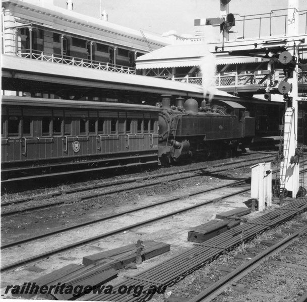 P02682
DD class steam locomotive, front and side view, AE class suburban passenger carriage, side view, signals, signal rodding, covered footbridge, Perth, ER line.
