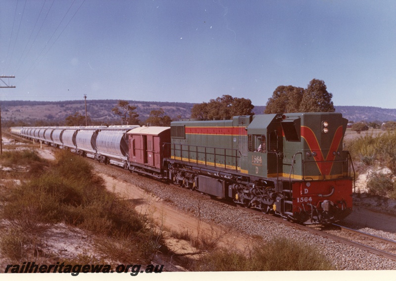 P03745
1 of 4, D class 1564 diesel locomotive hauling XF class alumina hoppers and brakevan, en route to Kwinana, side and front view.
