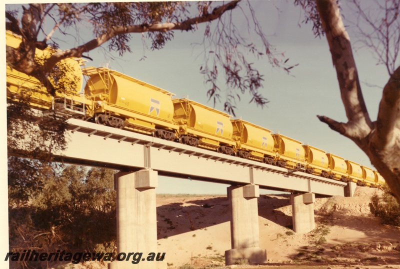 P04023
Train of XE class mineral sand wagons, crossing steel and concrete bridge, Irwin River. DE line

