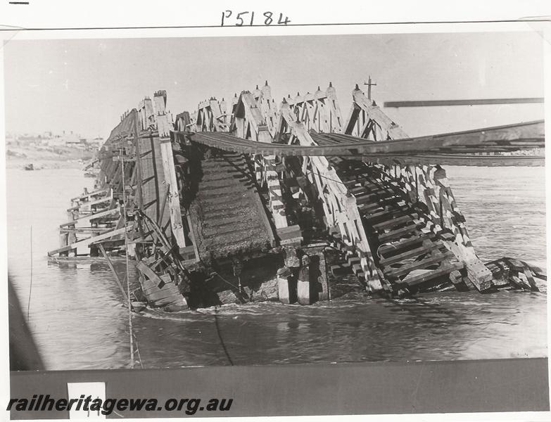P05184
Fremantle Railway Bridge collapse which occurred on the afternoon of the 22nd of July, 1926, view along the bridge with the rails suspended over the gap due to the washaway, ER line, See also P0592
