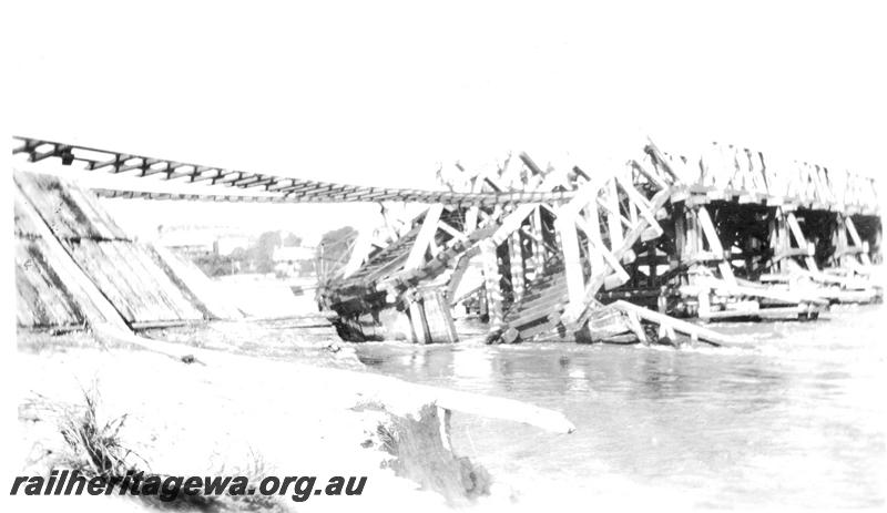 P07086
Fremantle Railway Bridge collapse which occurred on the afternoon of the 22nd of July, 1926, view along the side of the bridge showing the trusses collapsed into the river, See also P21471, ER line.
