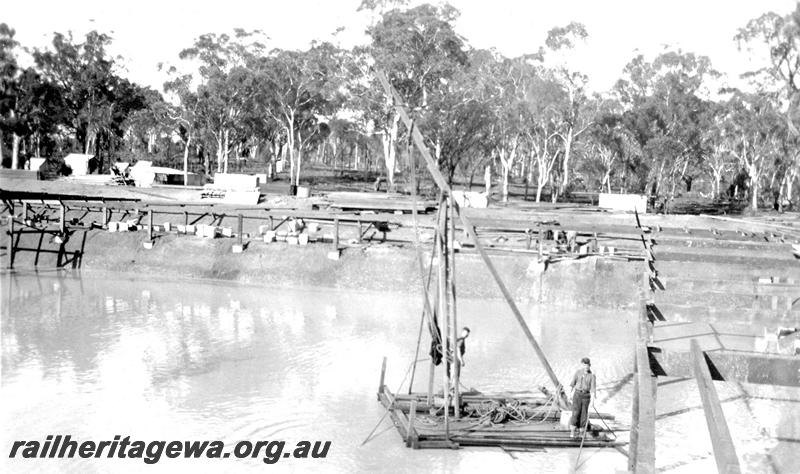 P07327
23 of 32 photos of the construction of the railway dam at Hillman, BN line, roofing in progress, workers on barge with derrick
