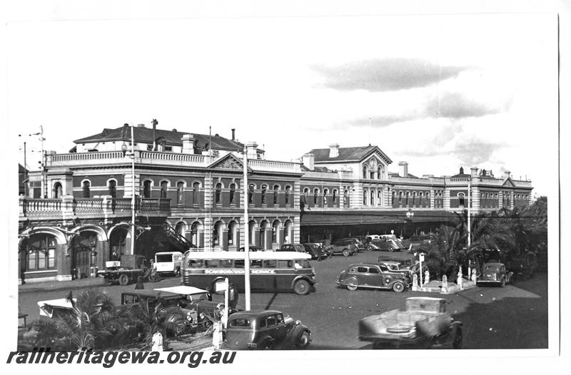 P07701
Perth Railway station forecourt with parked cars,  Wellington Street with traffic, looking east. Scarborough Bus Service bus in foreground. ER line. Same as P23266
