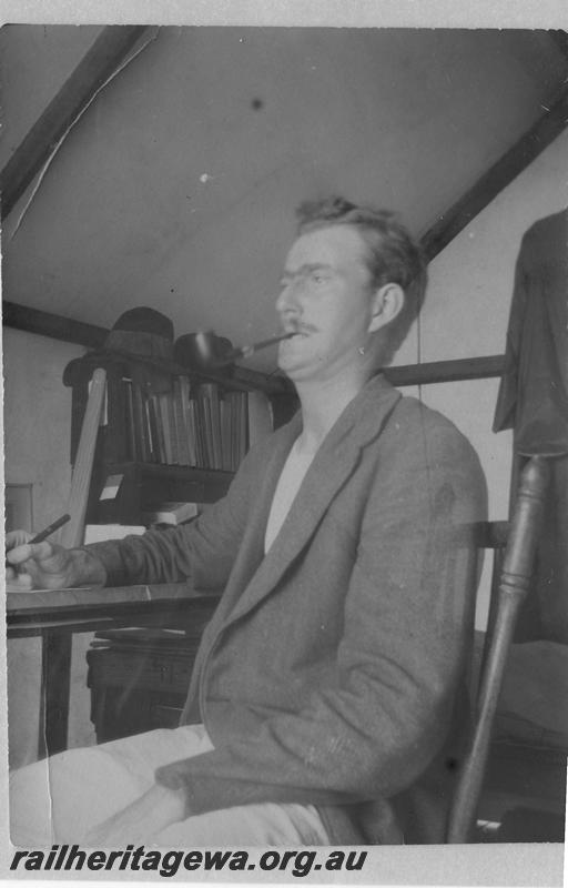P08911
27 of 29 views of the construction of the Wyalkatchem-Lake Brown-Southern Cross railway, WLB line. Man a desk with bookshelves in background, possibly the engineer in charge

