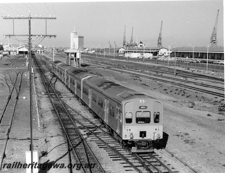 P10309
ADL class four car railcar set departing Fremantle for Perth, telegraph pole, signal box, Fremantle yard, station in the background, elevated view looking west.
