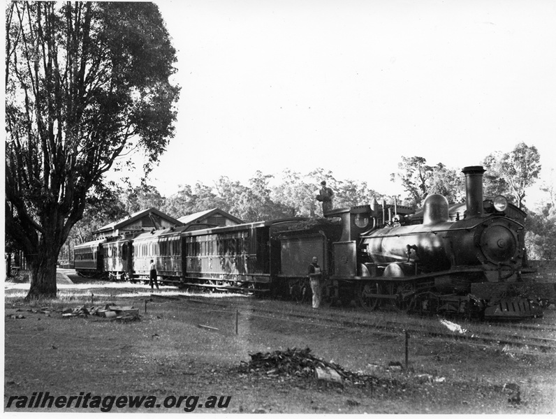P10383
Commissioners South West Inspection Tour train at Greenbushes.  Train hauled by the former WA Land Companys locomotive Gordon now T class 170 with carriages AD, APC, AL class 39, AM class  313 alongside goods shed with crew on tender and near tender, PP line
