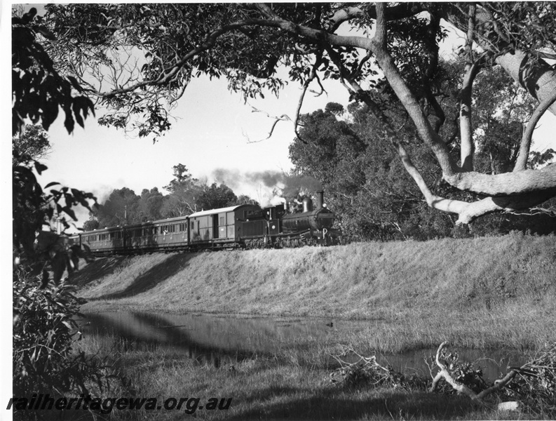 P10443
G class 233 steam locomotive and Z class 492 brakevan at head of the Vintage Train at Burekup on the . BB line. This was a  hired passenger special from Bunbury Jetty to Beela and return for crew of Leander-class frigate HMS Scylla of the Royal Navy. 
The train consisted of three ACM Class suburban dogbox carriages sandwiched between two Z Class brakevans. 
