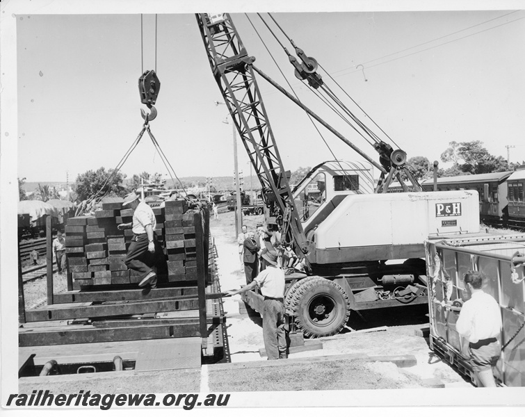 P10671
P & H mobile crane, unloading sleepers from flat wagons, workers, bracket signals, various wagons and carriages, Midland yard, side view
