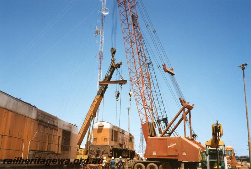 P12529
Port Hedland, Nelson Point, hard stand area, former Goldsworthy A class No.5 English Electric loco being loaded onto a road float for transporting south
