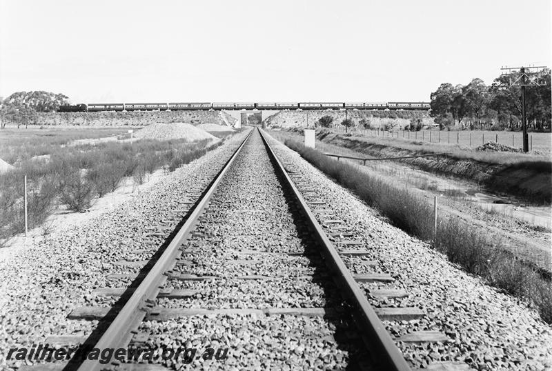 P12765
DD class hauling a tour train over the Kenwick Flyover, distant view taken looking down the standard gauge line.
