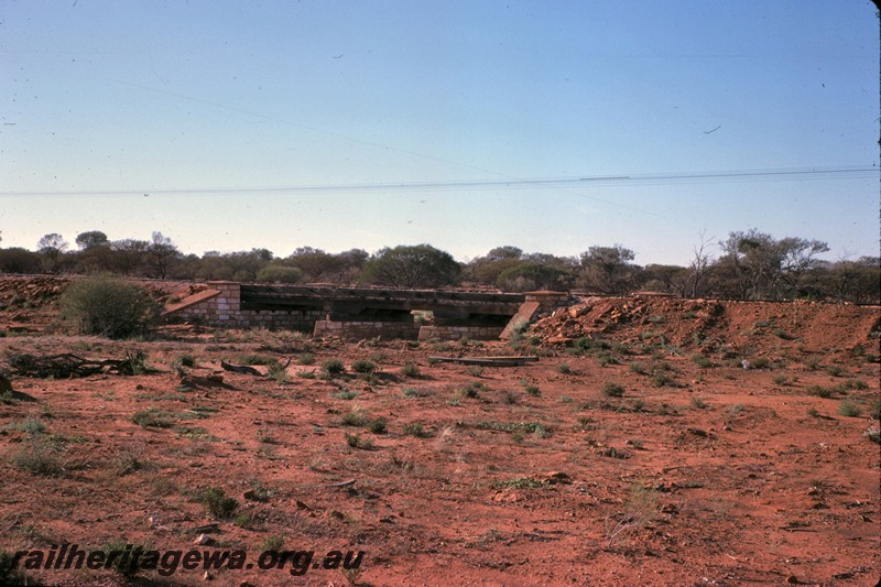 P14439
Timber bridge with stone (masonry) abutments and pylons, a low bridge near Edah siding, on the Yalgoo to Mount Magnet line, NR line.
