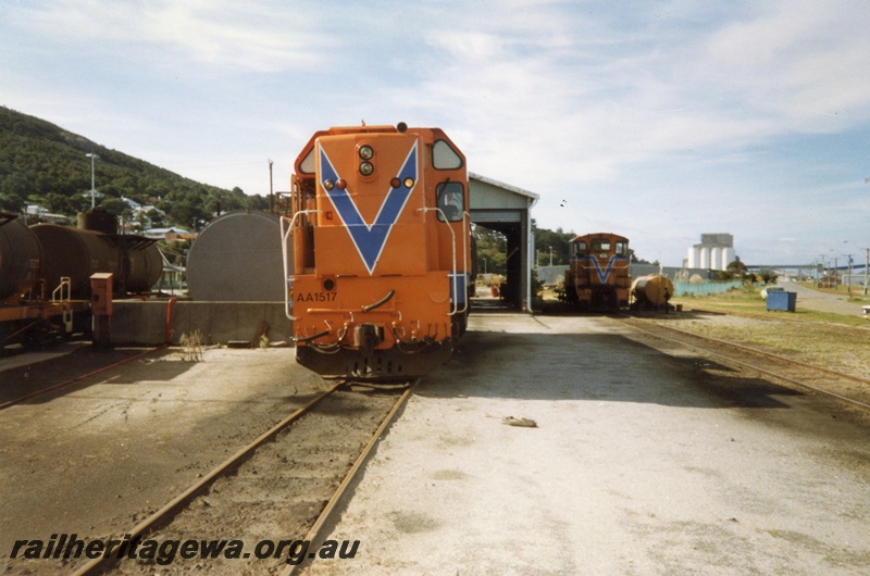 P15338
AA class 1517 diesel locomotive and TA class 1809 pictured at the fuelling point at Albany Locomotive depot. GSR line, Rail bogie fuel tankers to left of loco. Grain silos in background. Front view of AA locomotive. 
