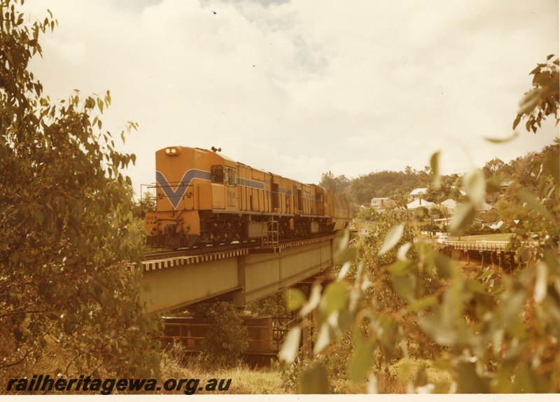 P15909
RA class 1909, in Westrail orange with blue and white strip, with another diesel loco, double heading woodchip train, crossing concrete and steel bridge, near Bridgetown, PP line
