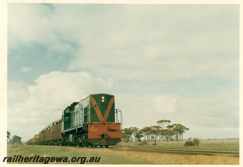 P15947
A class 1507, in green with red and yellow stripe, on wheat train, rural setting, side and front view
