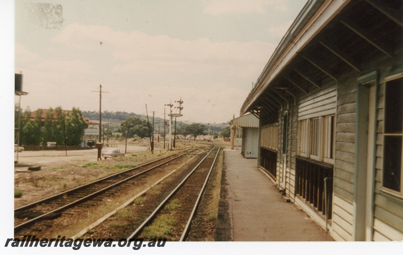 P16303
Former Refreshment stall at Spencers Brook looking east. A waiting area is between the refresh and the station building with the Spencers Brook Hotel to the left. A water column is on the platform near the station building, ER line.
