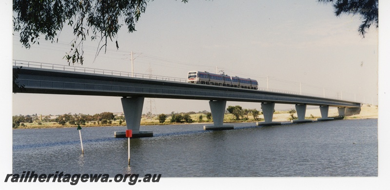 P16342
EMU two railcar set, crossing Swan River on concrete and steel Goongoongup bridge, East Perth, SWR line, front and side view, c1995
