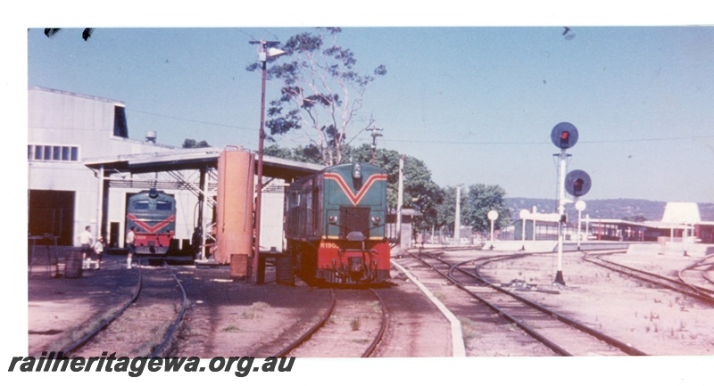P16498
R class 1902, X class diesel, both in green with red and yellow stripe, at refuelling point, shed, light signals, Midland station, ER line 
