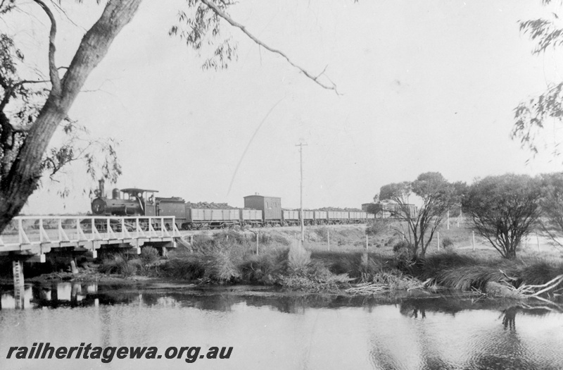 P16962
A Class loco with 6 wheeled tender, on goods train, crossing wooden bridge over Vasse River, near Busselton, BB line
