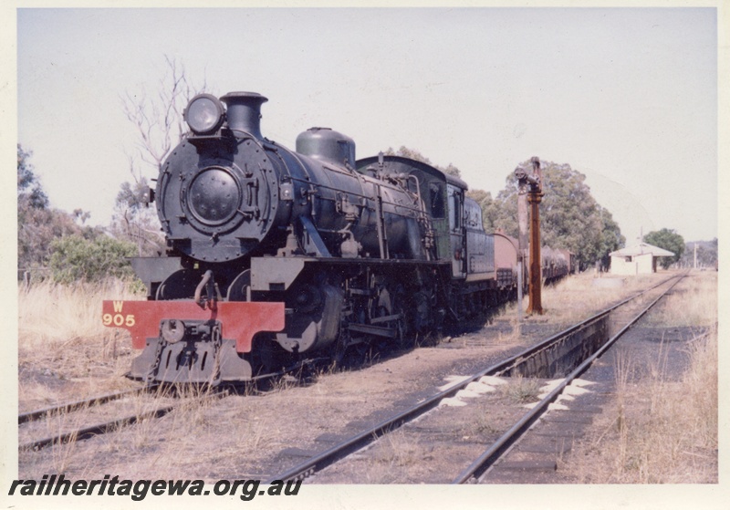 P17055
W class 905 at the head of a goods train, water column, ash pit , loco sand on the rails, station buildings in the background, view along the train , Bowelling, BN line, 
