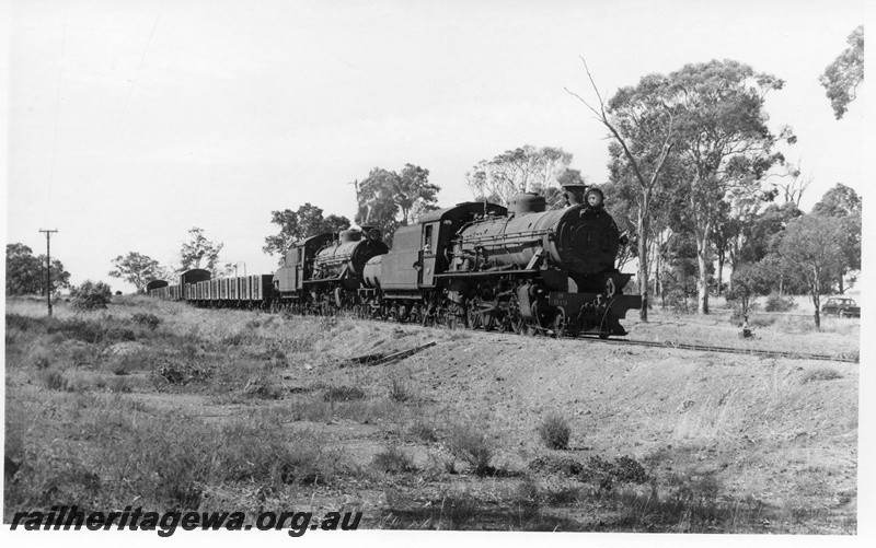 P17376
W class 919, W clss 914 steam locomotives at the head of 54 Goods leaving Duranillin. WB line. Leading wagons are 4 wheeled open type returning to load superphosphate.
