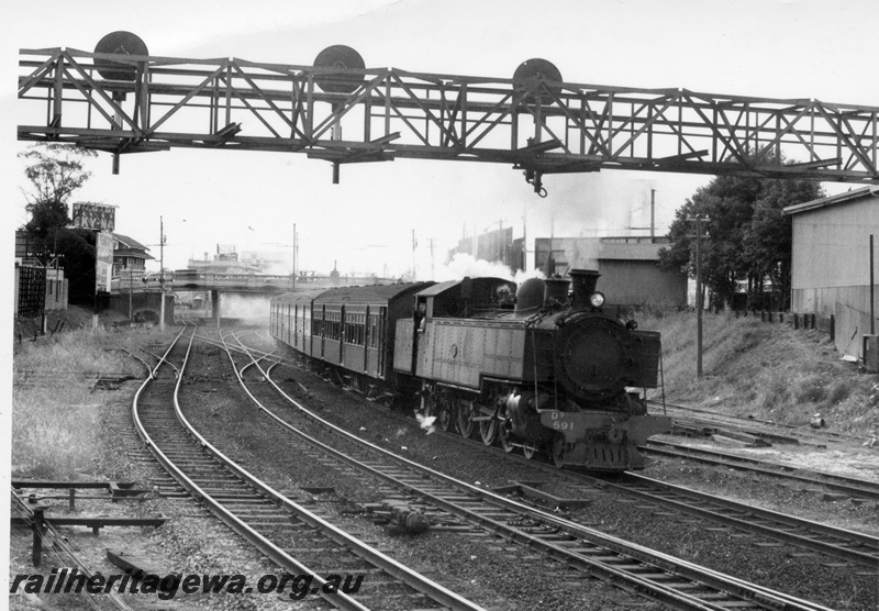 P17693
DD class 591, on Midland-bound passenger train comprising AYB class carriage behind the locomotive and AY class carriages, overhead road bridge, signal box, gantry signals, departing Perth station, ER line, side and front view. Same as P20822
