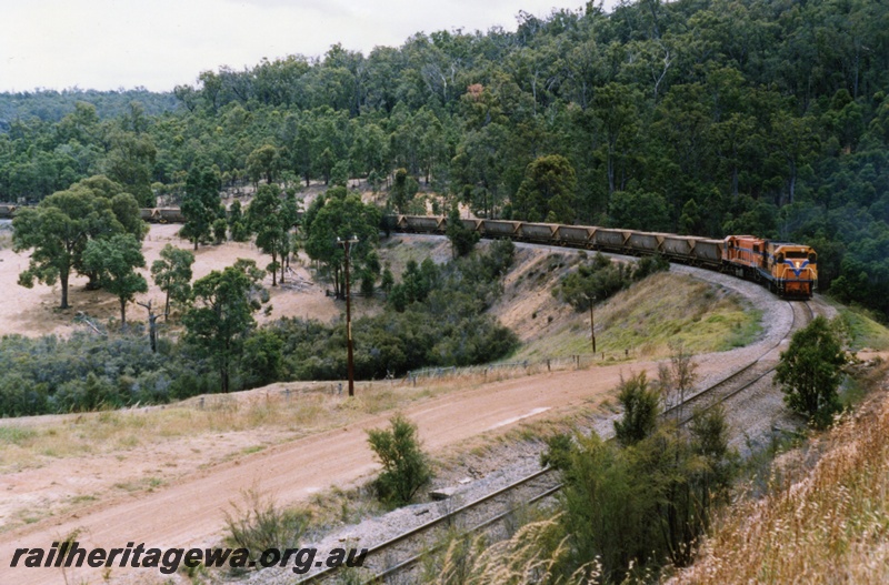 P18023
N class diesel and DB class diesel, double heading goods train, Jarrahdale, view of train approaching on a bend from elevated position
