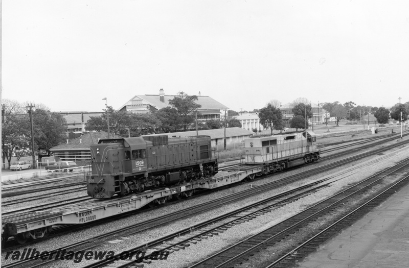 P18162
L class 268, heading westbound freight train including WFL class 30060 and WFL class 30059 flat wagons on which is loaded A class 1509, passing Midland Workshops, moving away from camera
