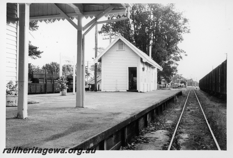 P18696
Platform, signal box, station nameboard, bracket signals, Boyanup Junction, view from track level
