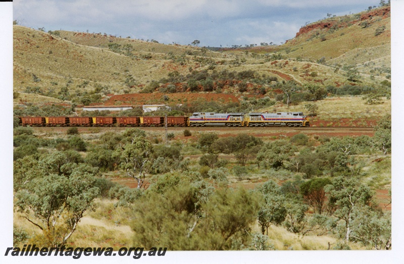 P18965
Hamersley Iron (HI) C44-9W class 7083, 7082 haul an empty iron ore train near Tom Price.
