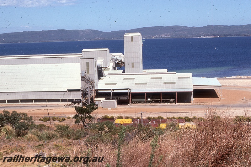 P19820
CBH grain facility, wheat bin, elevators, conveyors, carriage and loco shed, wagons in foreground, harbour in background, Albany, GSR line
