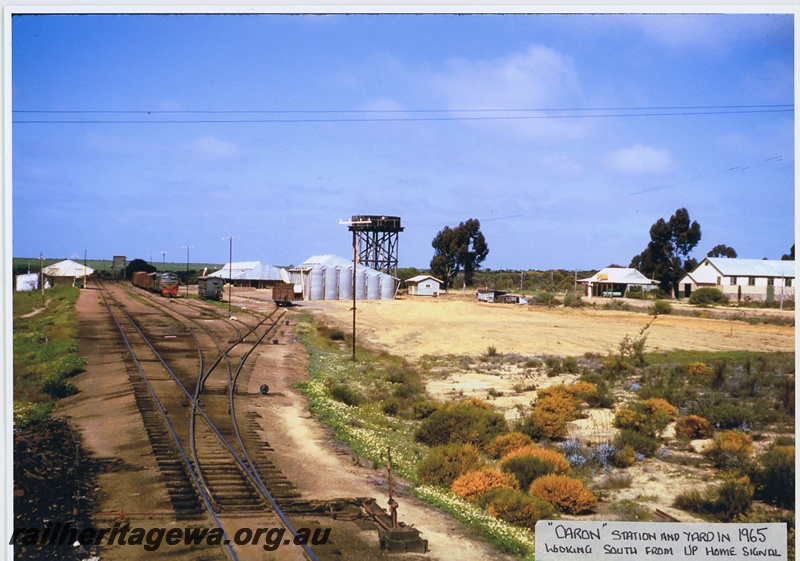 P20042
Station and yard, station building, points, sidings, X class loco in green livery with red and yellow stripe, on goods train, wheat bins, water tower, buildings, point lever, Caron, EM line, view form up home signal looking south
