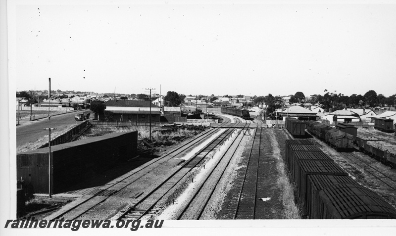 P20073
Steam hauled passenger train No 4, arriving at Northam from East Northam, houses, tracks, level crossing, signal, sidings, wagons, ER line, view from elevated position
