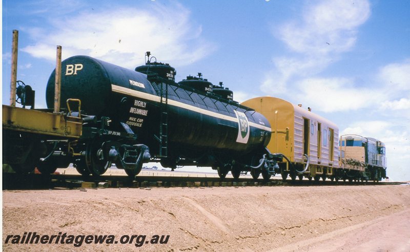 P20770
H class (original light blue livery) hauling a standard gauge construction train near Doodlakine.  Rear view of train showing  JTE class 340 BP fuel tanker and WBA class brakevan. EGR line. 
