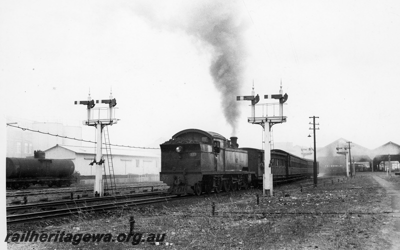 P20814
DS class 377, bunker first, on passenger train comprising AD, AS, AT and AU class carriages, departing Fremantle, two sets of bracket signals, tanker wagon, sheds, Fremantle, ER line, end and side view 
