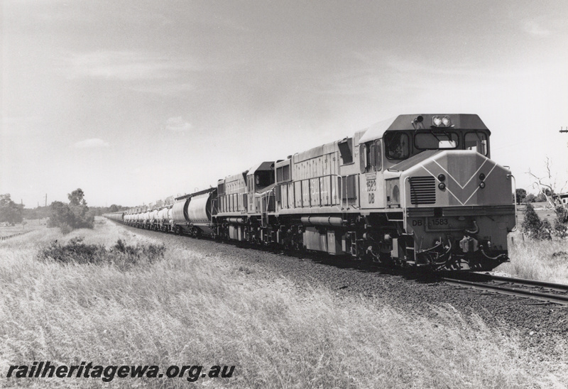 P20872
DB class 1583 double heading with another DB class hauling caustic soda and alumina wagon towards Bunbury, SWR line, side and front view along  the train
