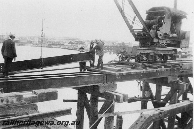 P20942
Reconstruction of Fremantle Railway Bridge after collapse in 1926 1 of 3, mobile crane placing girder, workers, bridge framework, port, Fremantle, ER line, view at track level. Bridge collapsed on 27 July 1926, and single line reopened 12 October 1926.
