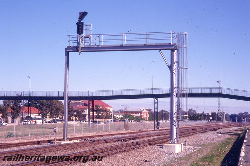 P21043
Steel signal gantry with colour light signals, Midland, the footbridge from the old Midland station platform to the Midland Workshops in behind the gantry, view looking west.
