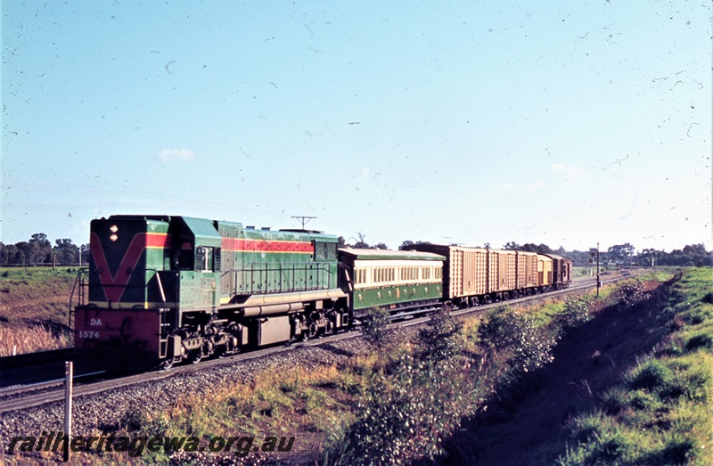 P21188
WAGR DA class 1574 in the green with red and yellow strips livery hauling a short goods train southwards through Hazelmere with ACL class 401 carriage in the consist
