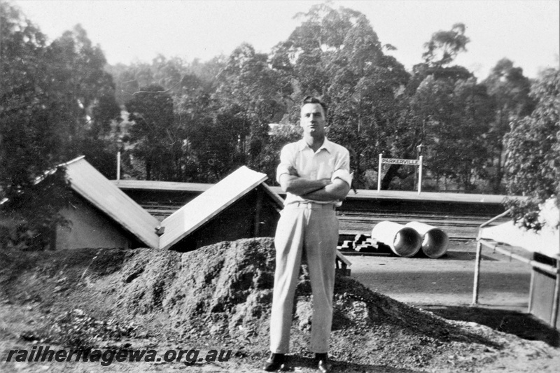 P21370
Platform, station nameboard, trackside buildings, drainage pipes, unknown man, Parkerville, ER line, c1932-1934
