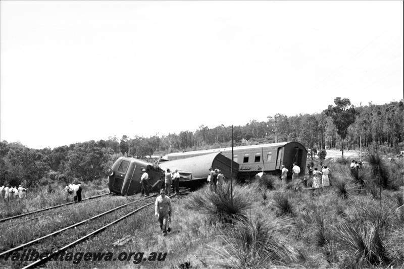 P21594
Derailment scene, X class 1005 on side, bogie van VA class 10220, AZ class 440  passenger carriage across tracks, crowd of onlookers,near Parkerville, ER line, view from trackside
