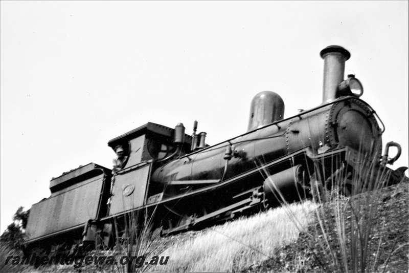 P21620
G class 107 with driver Gordon McIntyre looking out of the cab, UDRR line,  side and front view looking up at the loco
