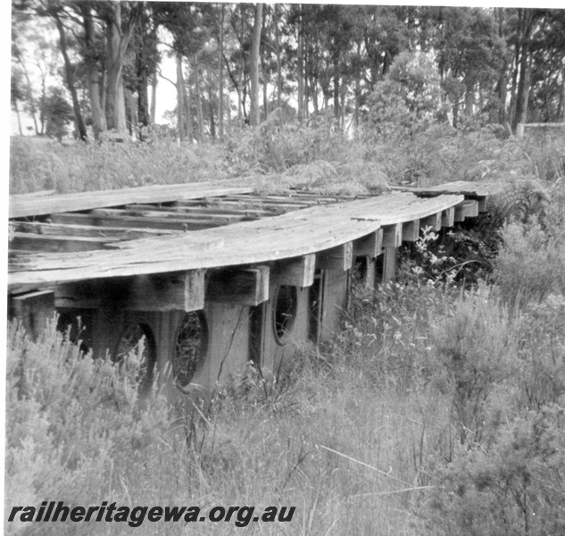 P21813
Sellers turntable, derelict, site overgrown, sleepers and deck still in place,  side view looking along  the deck  , Denmark,  D line. 
