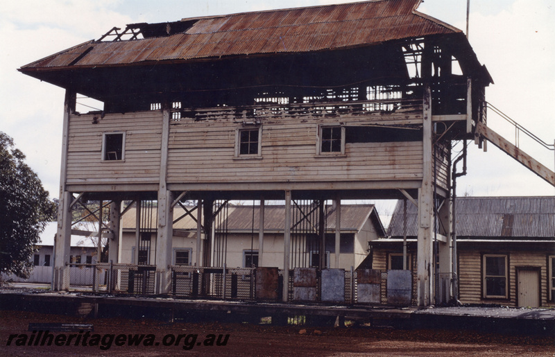 P21915
Signal box, gutted by fire, on stilts on platform, station buildings, Northam, ER line, side view from ground level
