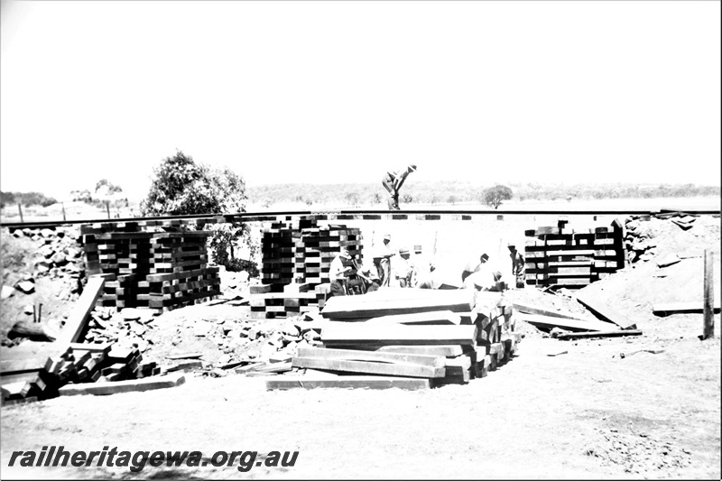 P21950
Construction of pigsty, after washaway, sleepers, workers, view from dry creek bed
