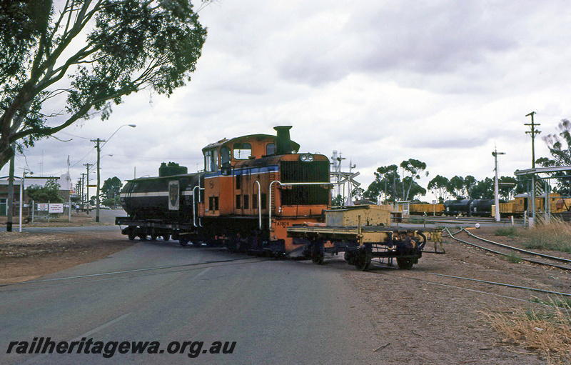 P21965
TA class 1806, with short flat wagon at front and BP tanker wagon at rear, on level crossing, bracket signals, signal, wagons in yard, sidings, Katanning, GSR line, side and front view
